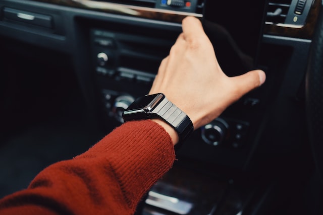 person with smart watch driving car