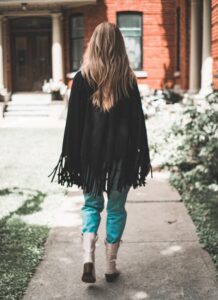 woman wearing black cardigan walking on pathway